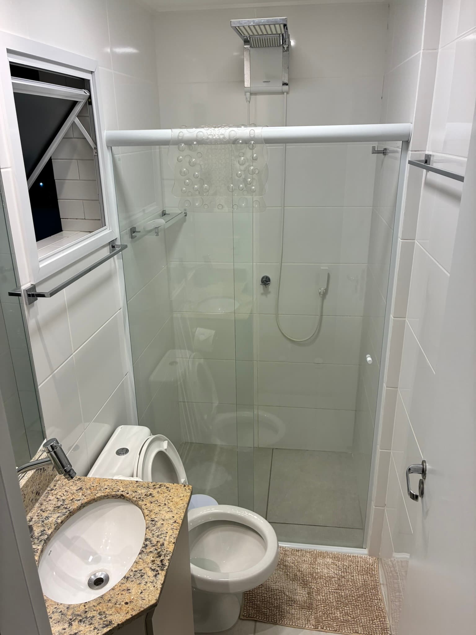 Primeiro banheiro do apartamento com box de vidro