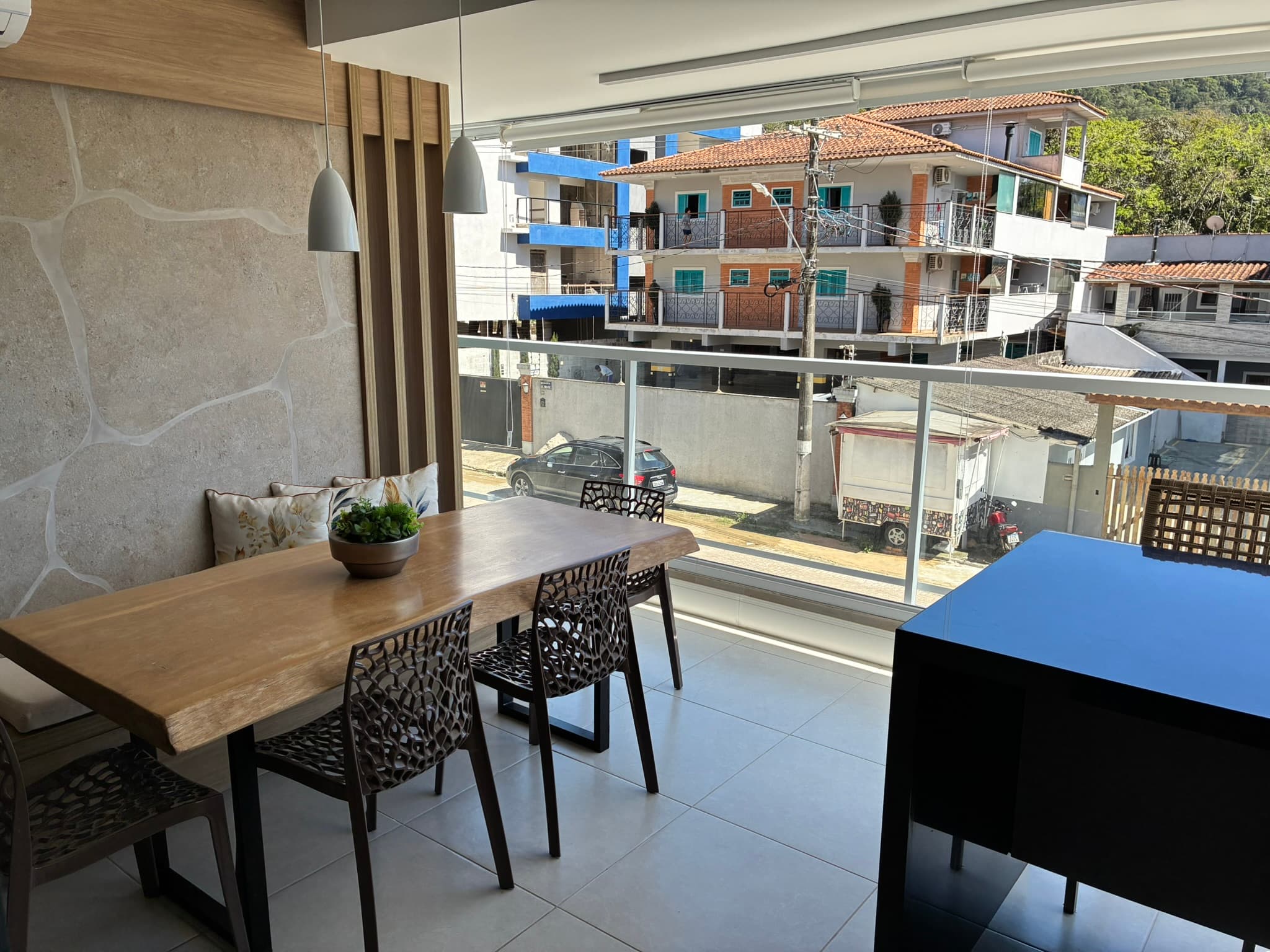 Mesa junto à varanda gourmet envidraçada