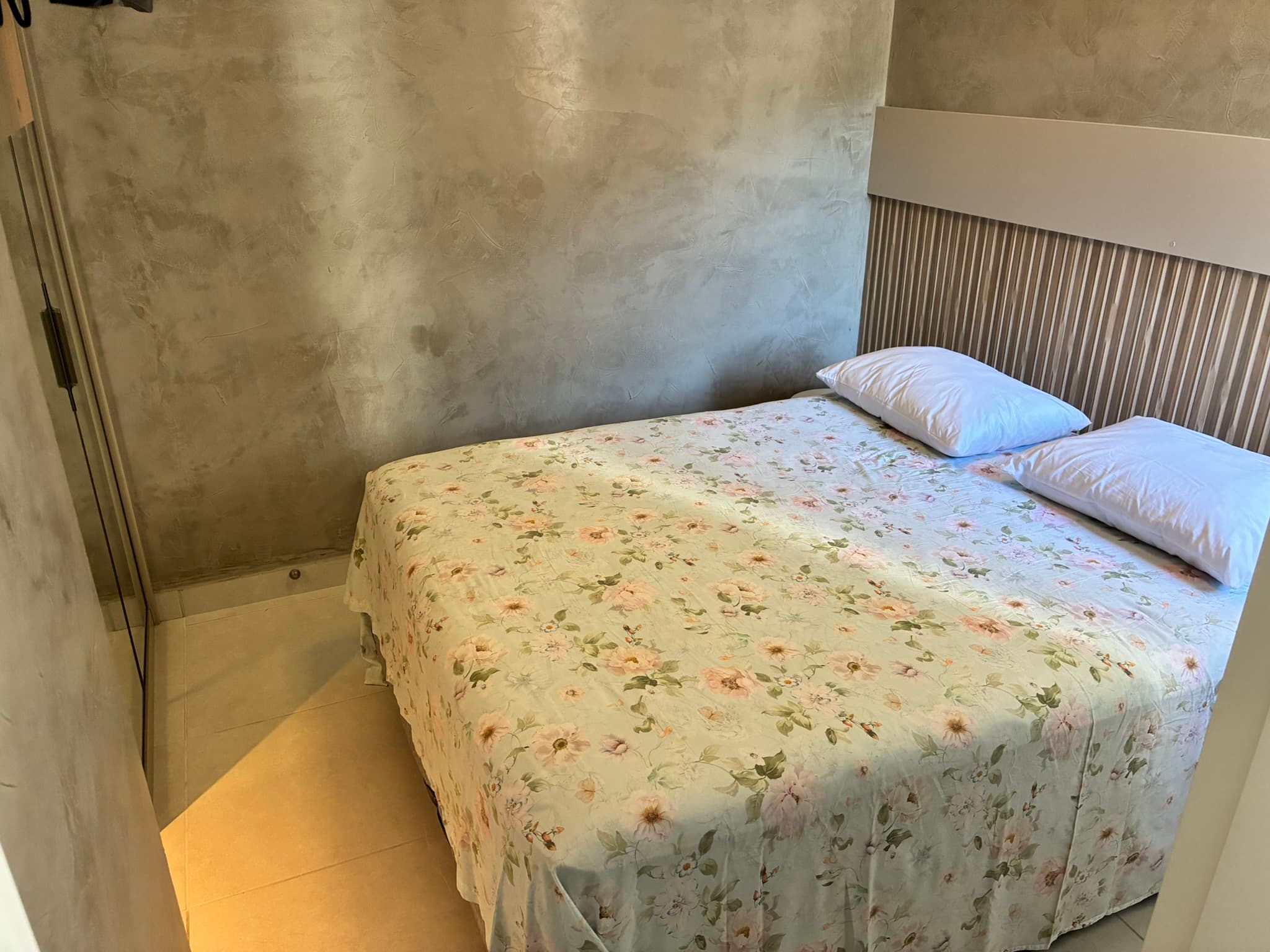 Quarto com cama de casal e cabeceira ripada