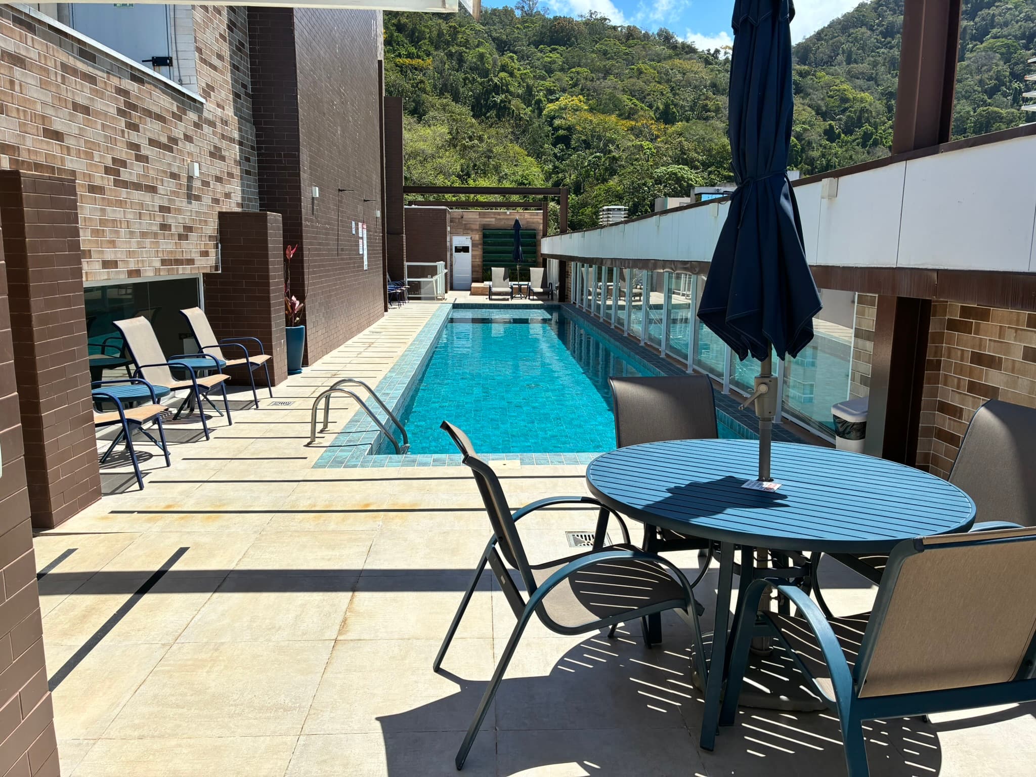 Piscina e área de descanso do condomínio